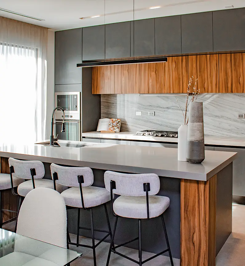Cocina moderna con detalles de madera y colores grises en Antea Residencial.