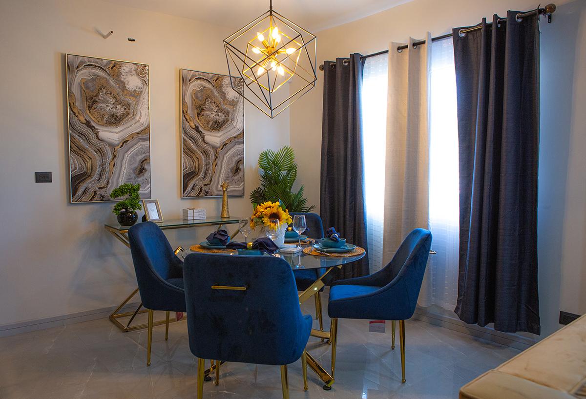 Elegante espacio de comedor con mesa y sillas en tonos azules y dorados.