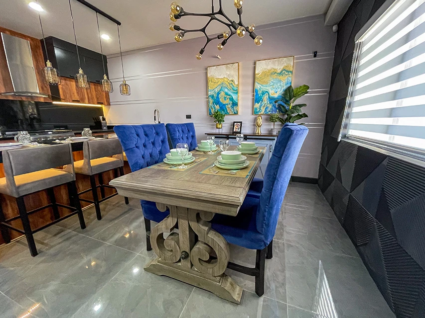 Comedor moderno con una mesa de madera rústica y sillas acolchonadas de color azul.