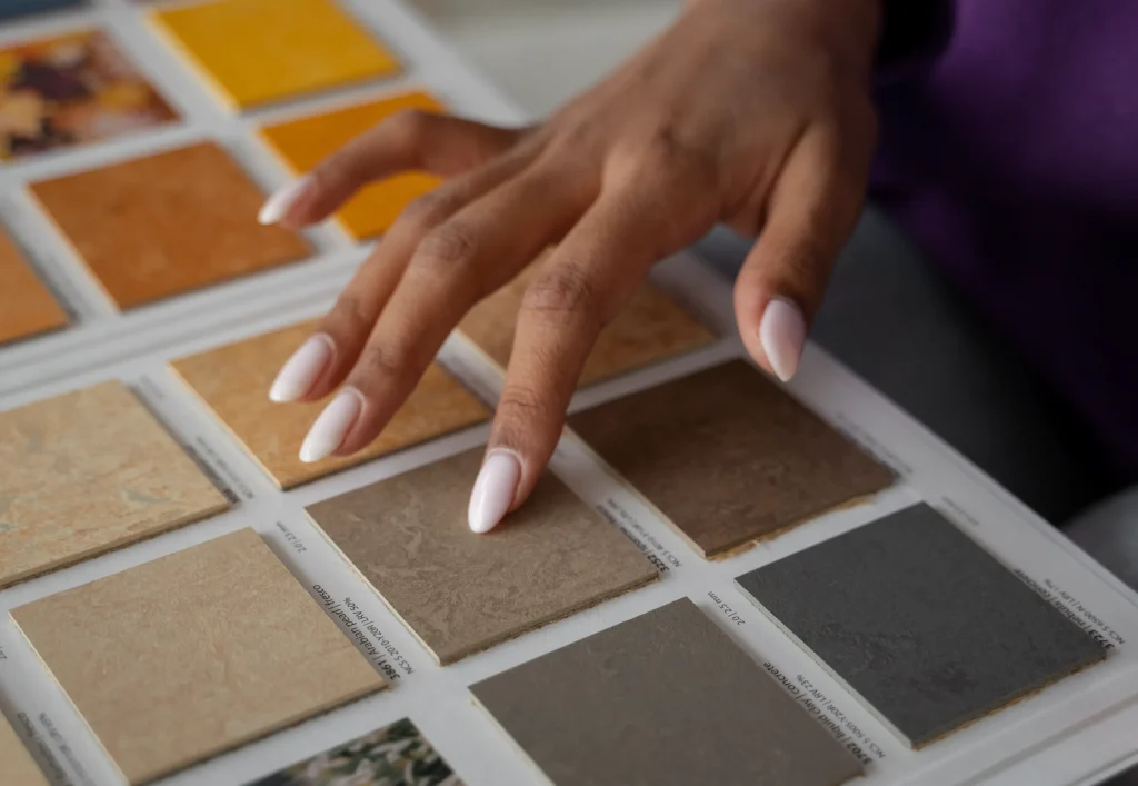 Mano de una mujer seleccionando un color de loseta