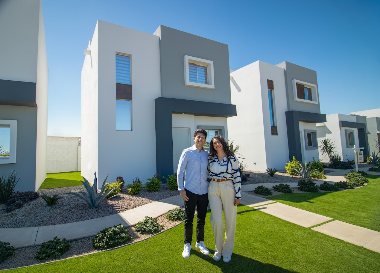 Pareja feliz en la sala de su nueva casa de Residencial El Marqués